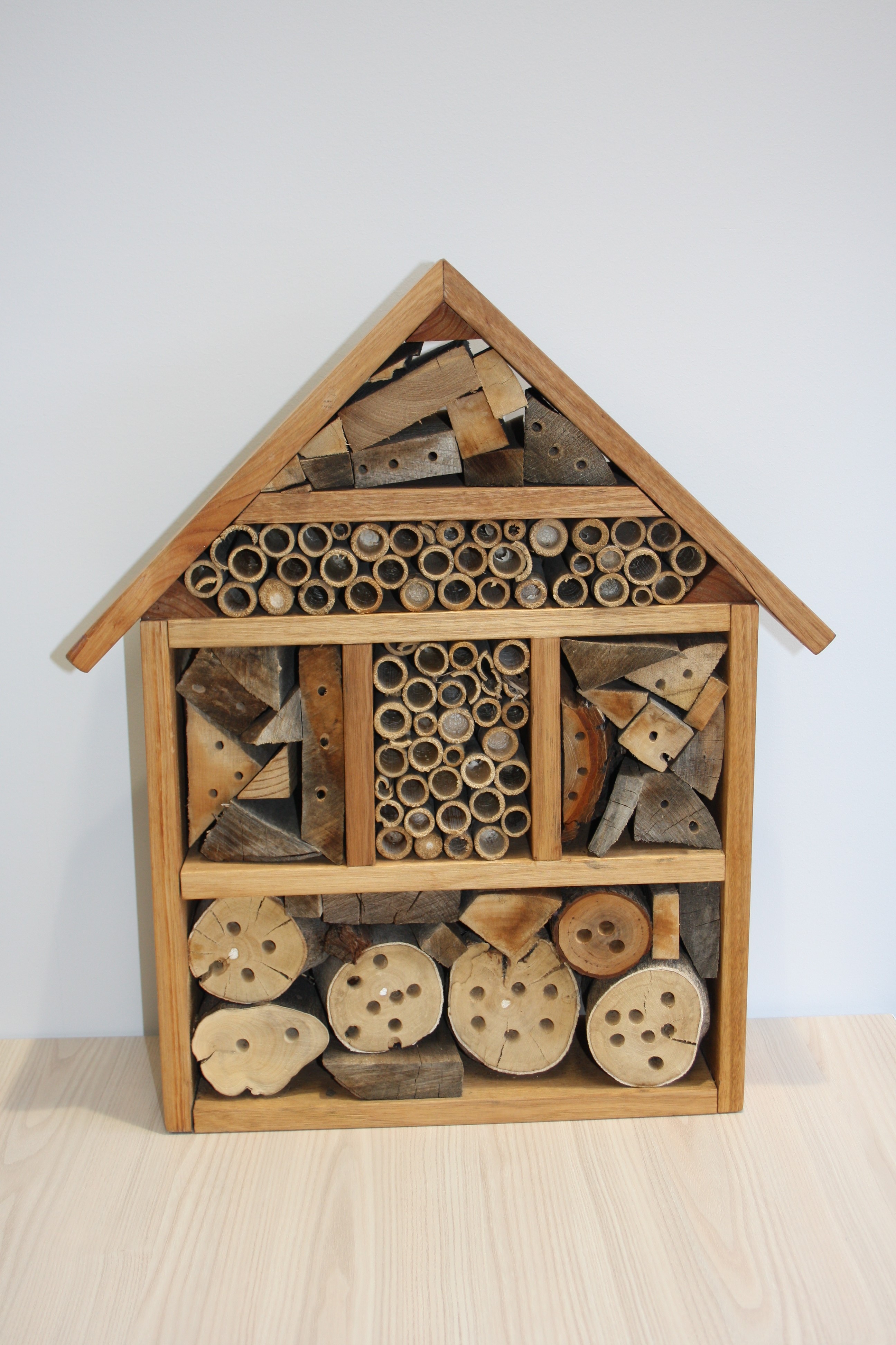 An insect house made up of different materials such as wood, bamboo, and recycled materials