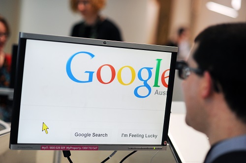 A computer screen shows the Google homepage being used with a screen magnifier