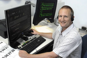 Richard sitting at a desk using adaptive technology on a computer